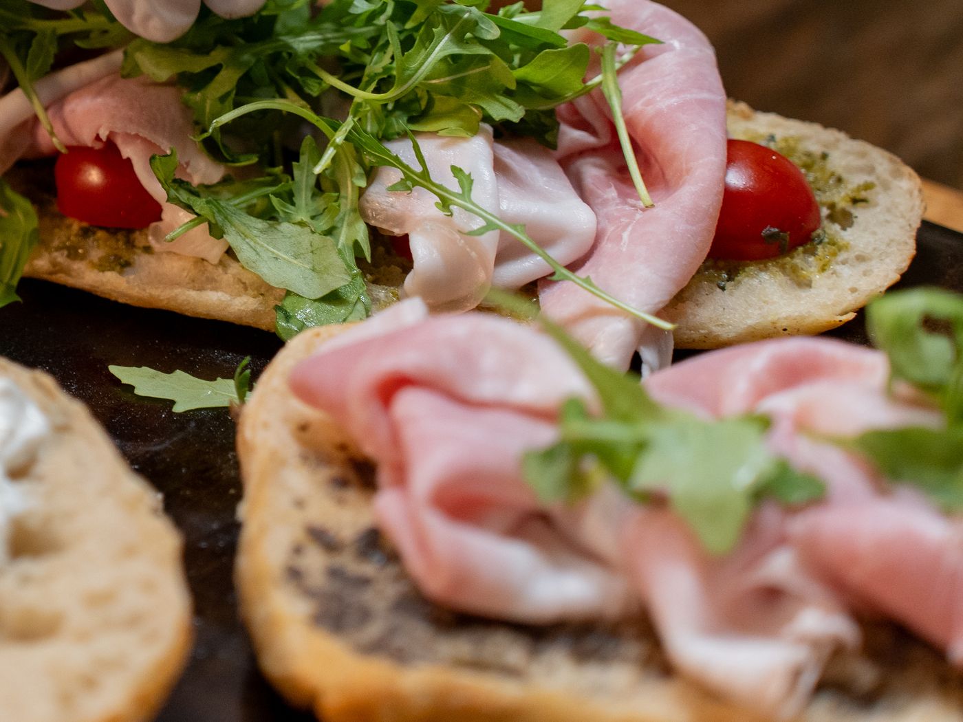 Open sandwiches with ham, rocket and cherry tomatoes on toasted bread
